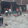 Tibetans prostrating in the courtyard before the entrance portico of the temple.