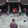 Tibetans prostrating in the courtyard before the entrance portico of the temple.