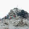 A cairn and prayer flags at the top of a pass.