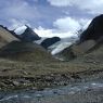 A view of a creek and a snow mountain.