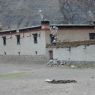 A Tibetan house with prayer flags on the roadside.