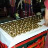 A table full of bronze offering bowls to be filled with water.