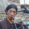 A Tibetan nomad young man holding a turquoise rosary.