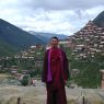 Monk Tashi Phuntsok with the monastery in the background.