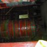 Lay Tibetans spinning a large prayer wheel.