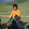 A young nomad boy riding a yak.