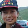 A close up of a 14 year old Tibetan girl wearing a baseball cap.