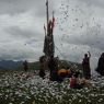 People offering paper prayer flags on top of one of the hills above Larung Gar.