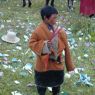 A young boy holding sticks of incense near the cairn.