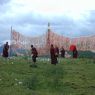 Monks near the prayer flag frame.