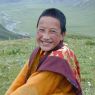 A young monk sitting on top of the hill.