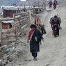 A nomad couple carrying meat to sell.