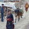 A nomad couple carrying meat to sell.