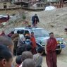 People bowing and greeting Khenpo Jikme Phutsok in the passenger side of the car as he arrives.