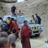 People bowing and greeting Khenpo Jikme Phutsok in the passenger side of the car as he arrives.