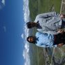 Tibetan and western man standing on a mountain over Lhagang town.