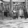 Pilgrims spinning prayer wheels and praying in front of the wall of carvings.