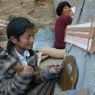 A Tibetan girl carving a prayer stone.