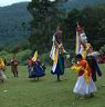 Nub chham dance performing in circle at meadow near by temple