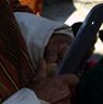 A man slicing the cover of betel nut at Nangkor tsechu