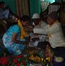 Brother applying flower garland to her sister