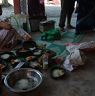 Rice being placed on plates made out of leaves.