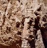 A masonry wall fragment with an ochre-tinted veneer surmounted by a tiered structure.