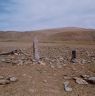 The walled pillars (foreground) and pillar array (background). Note the walls of the enclosure and the dislodged pillar on its left side. It appears that this pillar was still standing when the Roerich expedition discovered the site in 1928.