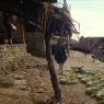 Bundles of split 'mah' on platform in front of Blacksmith houses