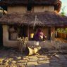 Woman using the quern at House31 Surna standing watching