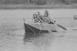 Architecture students paddling cardboard boat