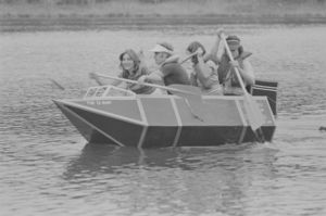 Architecture students paddling cardboard boat