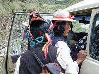 Tibetan women wearing hats, braids, and turquoise hair ornaments.