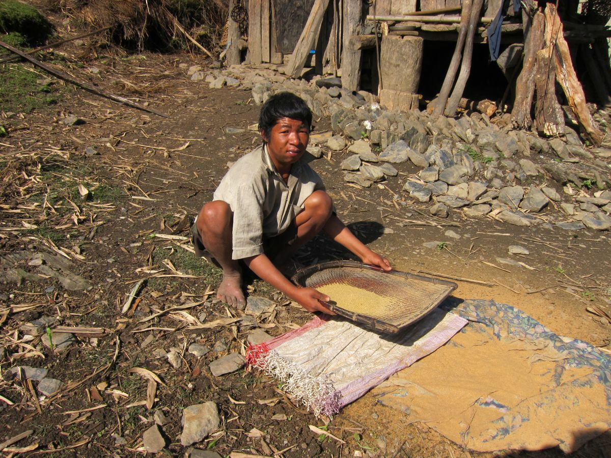 A Bhutanese man winnowing millets. | Mandala Collections - Images